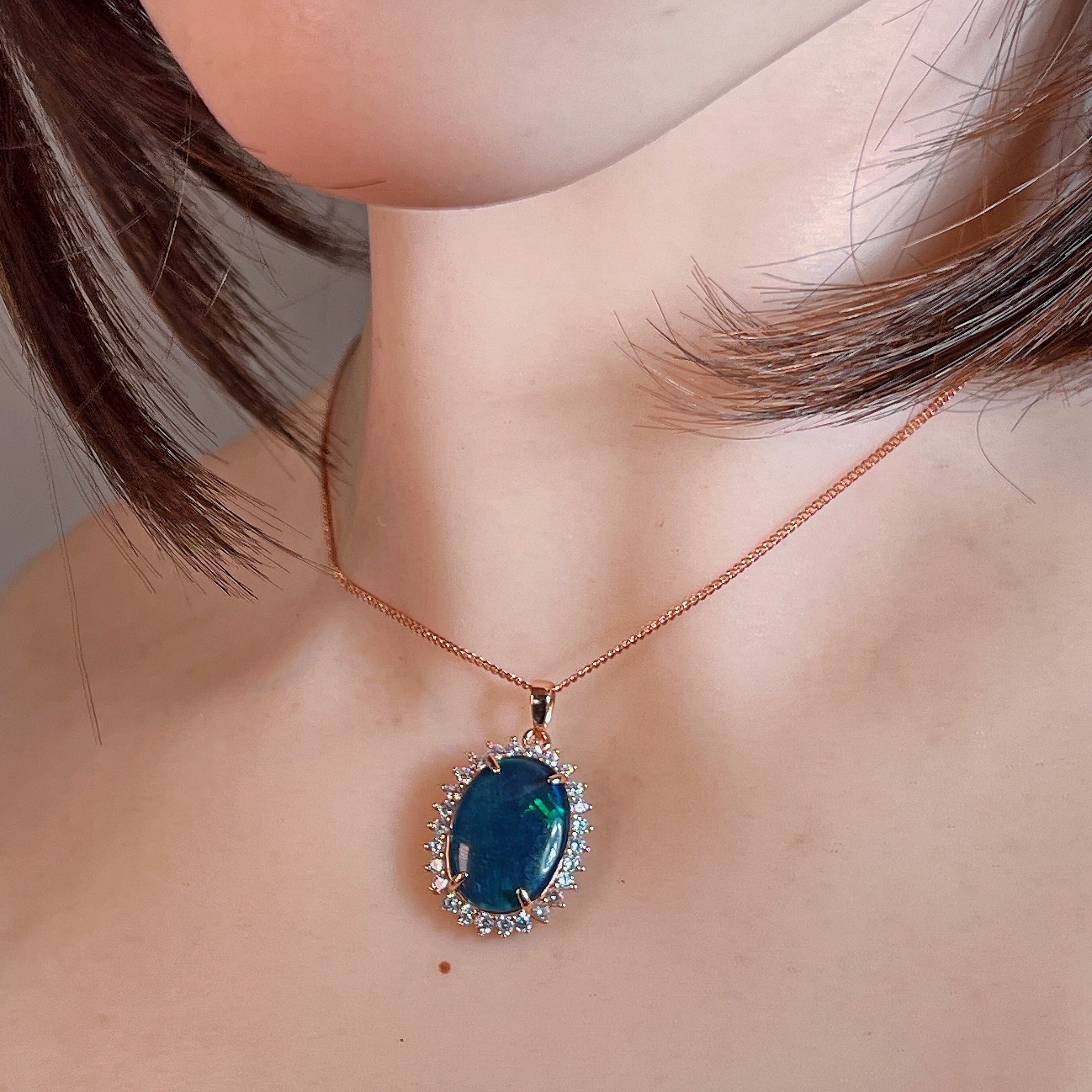 Rose gold-plated opal triplet halo pendant worn at the neck on a fine chain