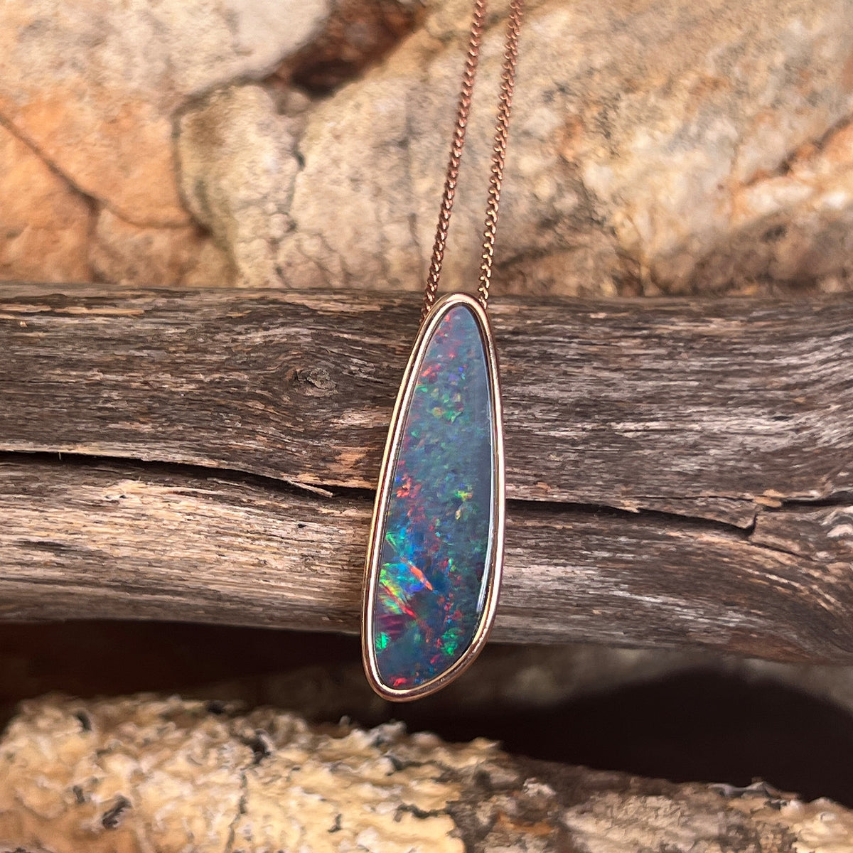 freeform Australian opal doublet pendant in rose gold-plated silver, red, blue, yellow and green play-of-colour