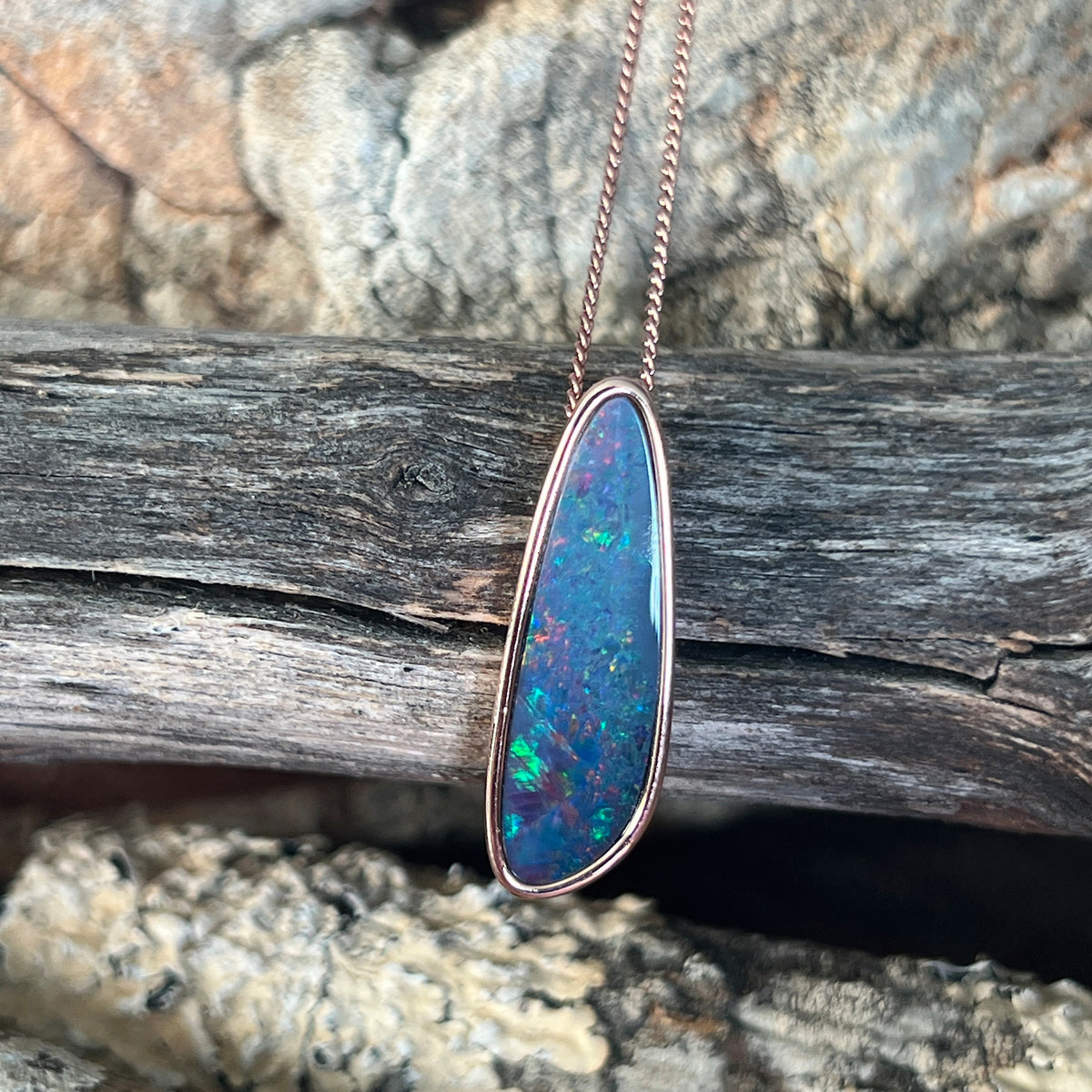 Australian opal doublet pendant, rose gold-plated silver, 27 x 8mm stone showing red, blue, yellow and green