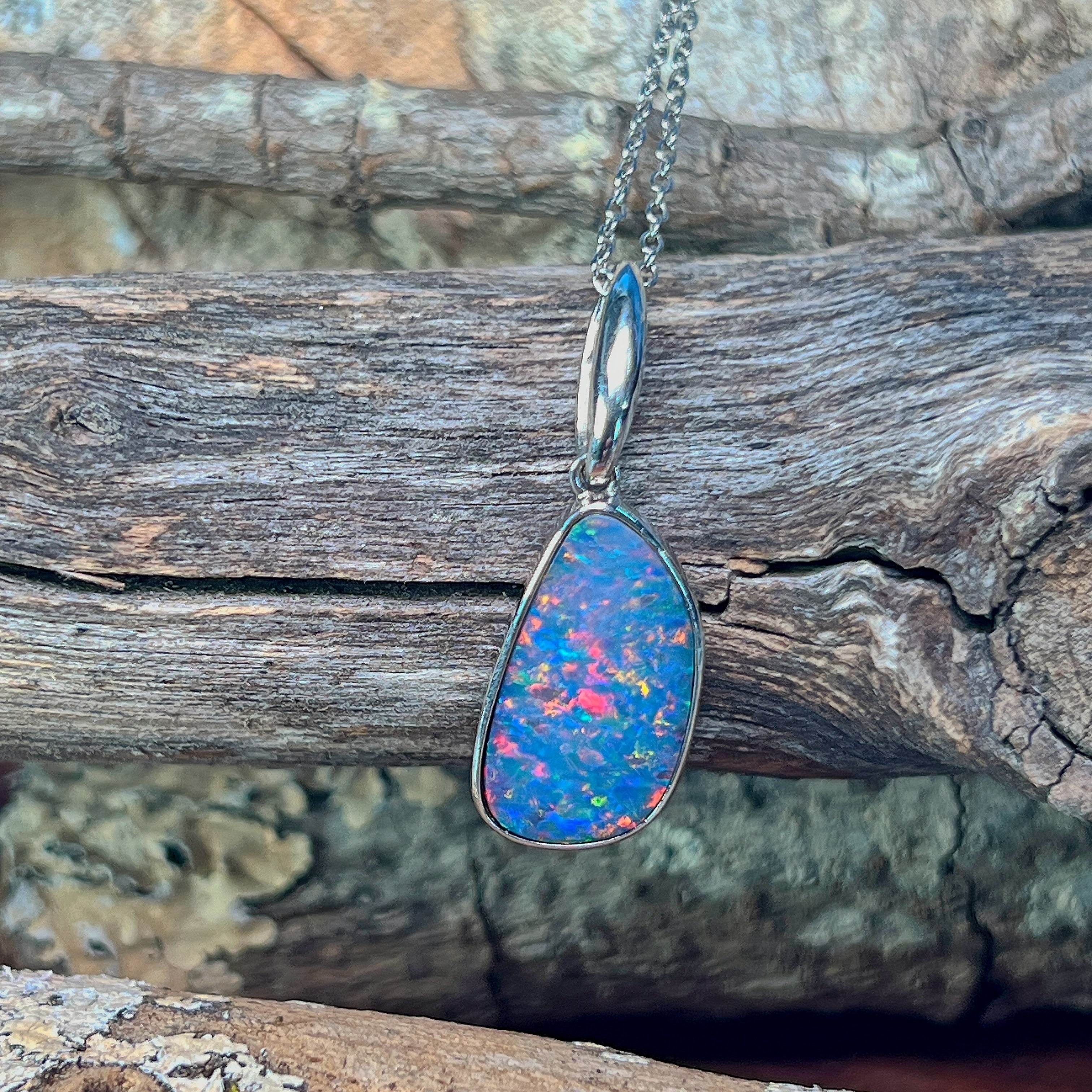 Sterling silver freeform opal doublet pendant angled to show its ribbed bail