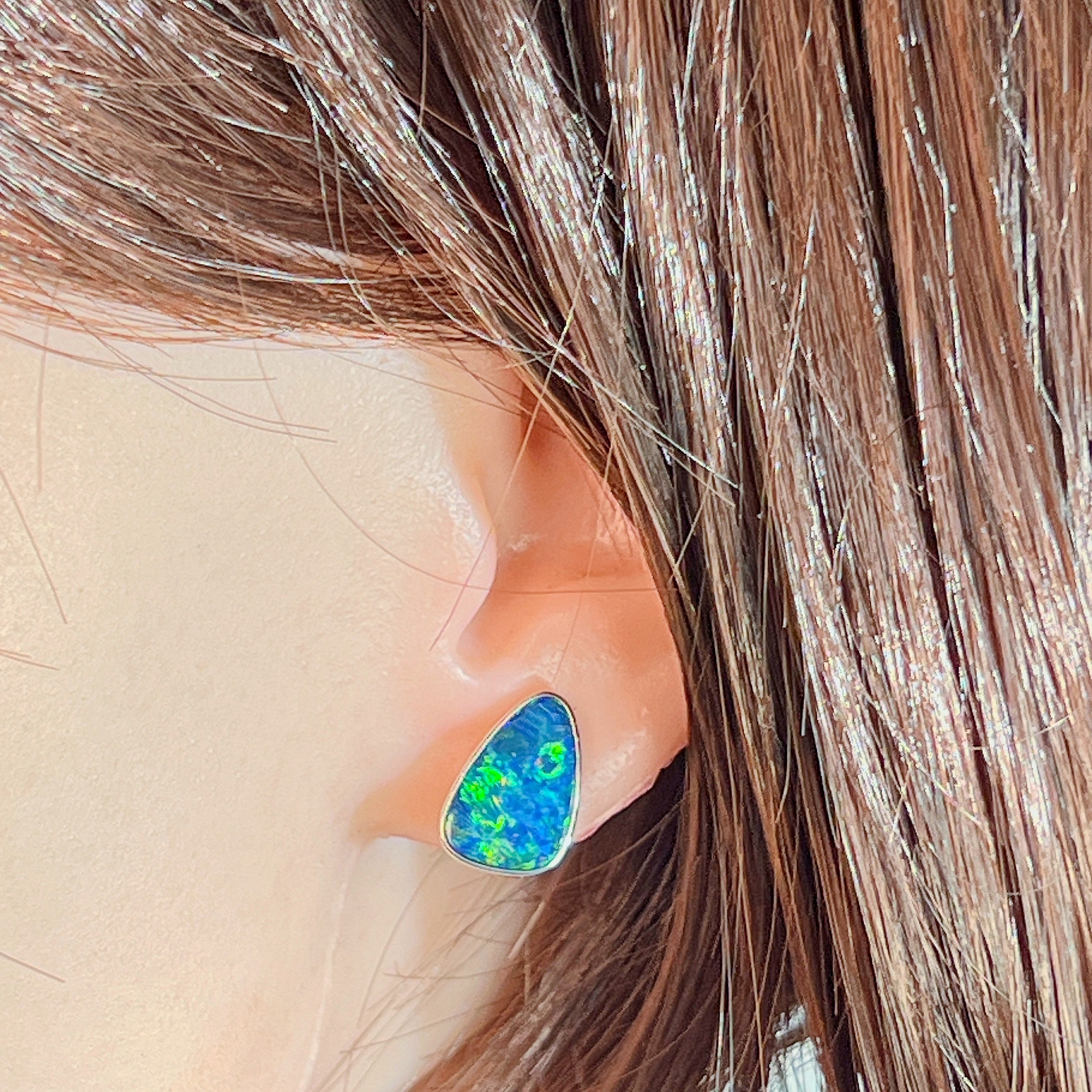 Freeform opal doublet stud earring worn on the ear, showing its scale on the earlobe