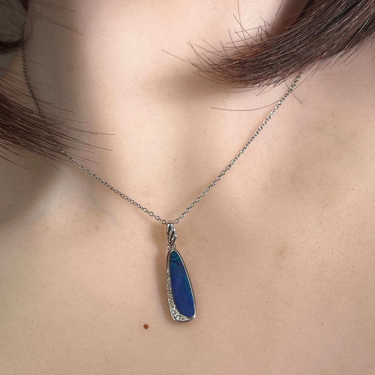 Australian opal doublet pendant worn at the neck, sterling silver, 20 x 6mm oval stone