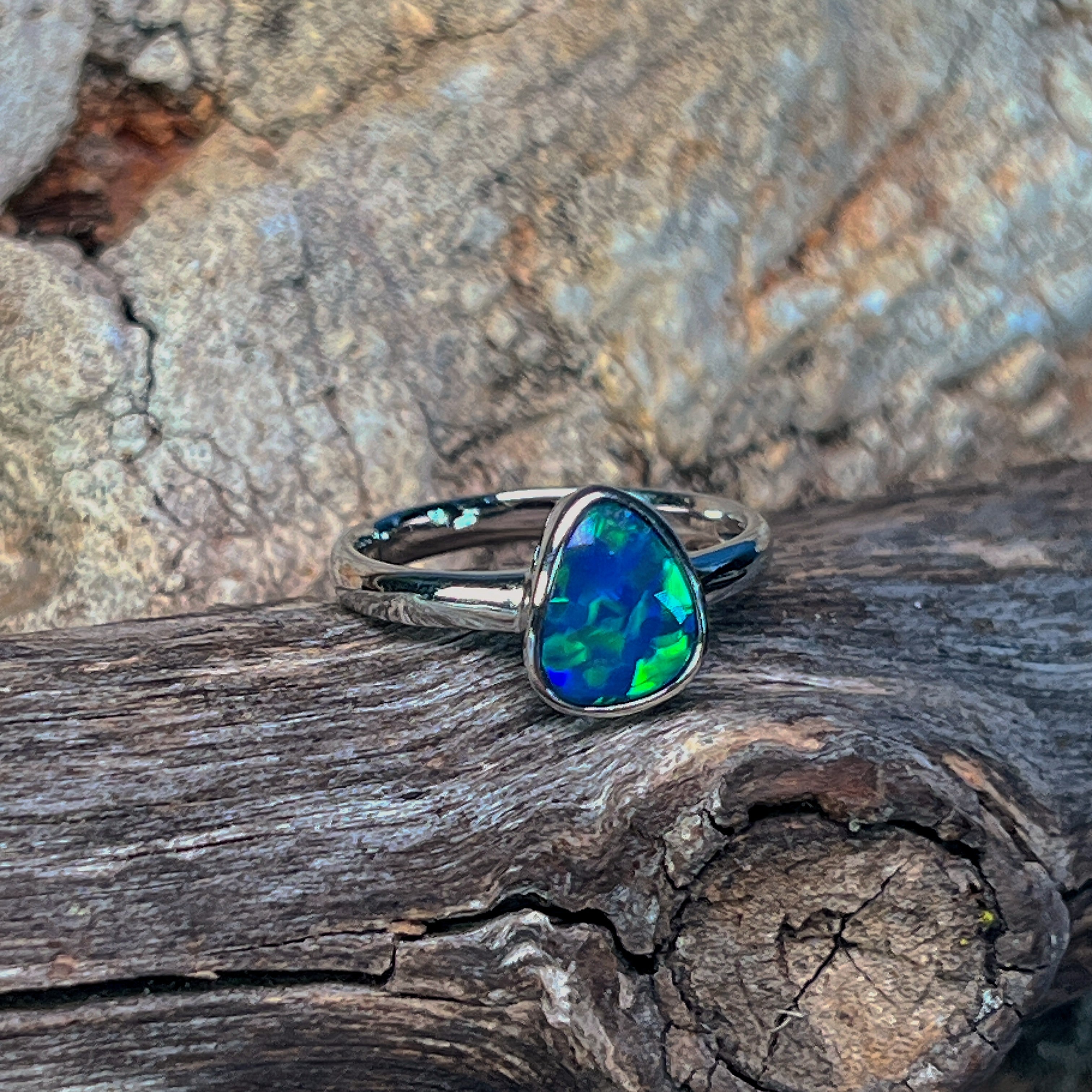 Pear opal doublet ring in silver viewed from the side, showing the slim band