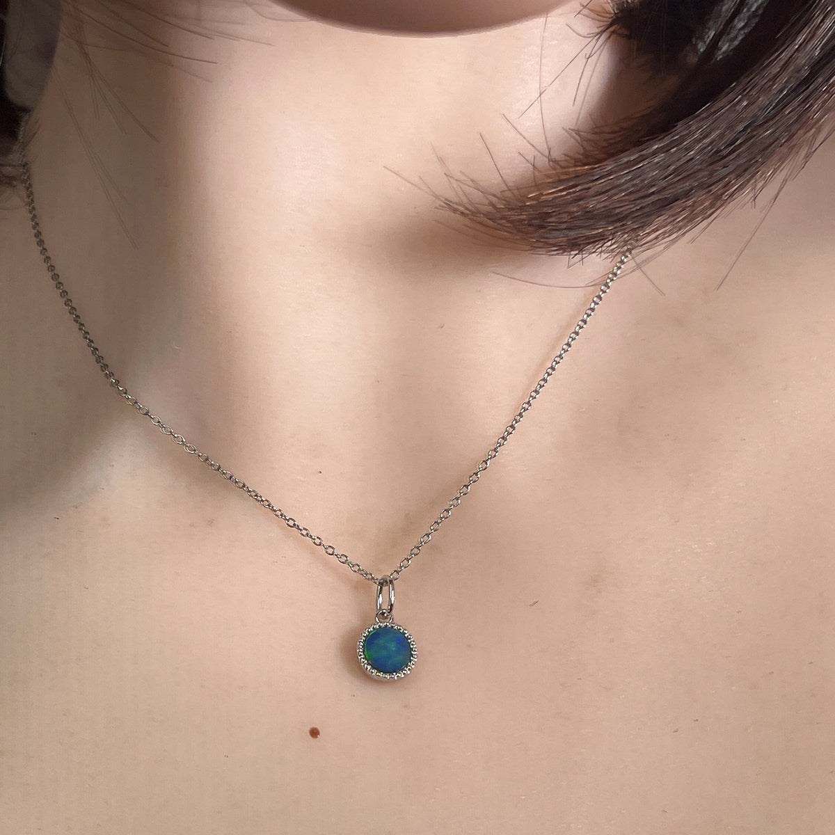 7mm round Australian opal doublet pendant worn at the neck, sterling silver