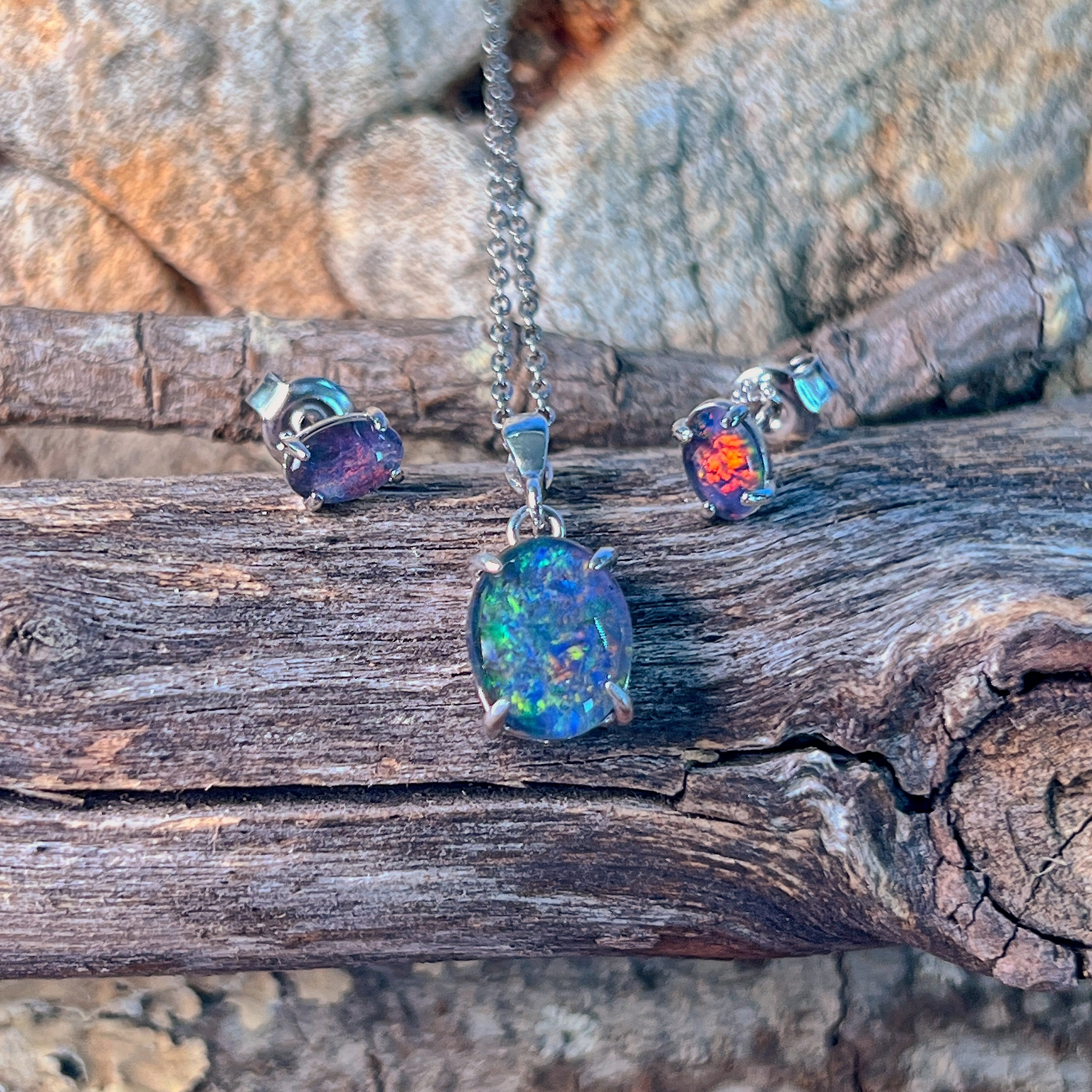 Claw-set oval opal triplet pendant in sterling silver showing blue and green fire