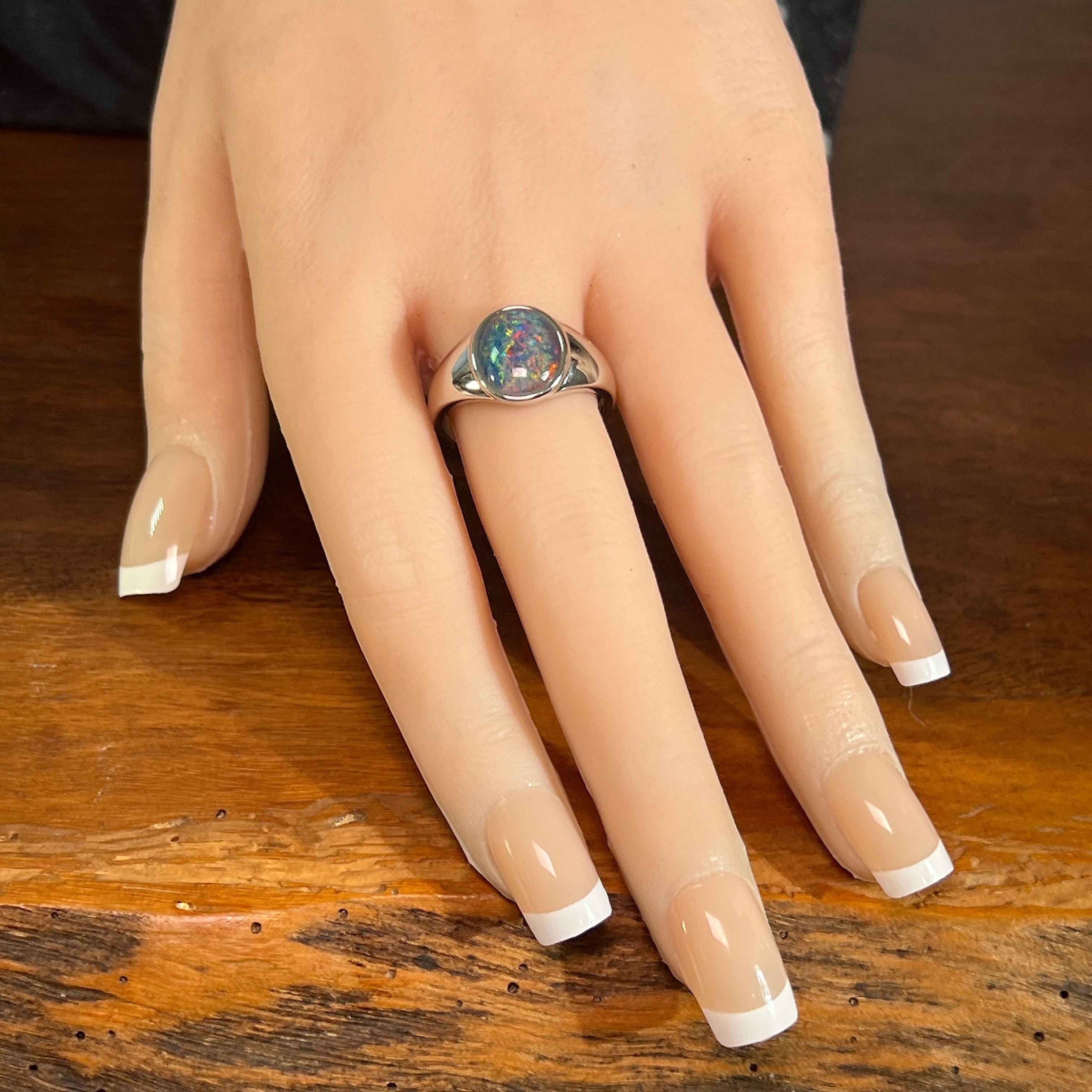 12 x 10mm oval Australian opal triplet ring on the hand, sterling silver