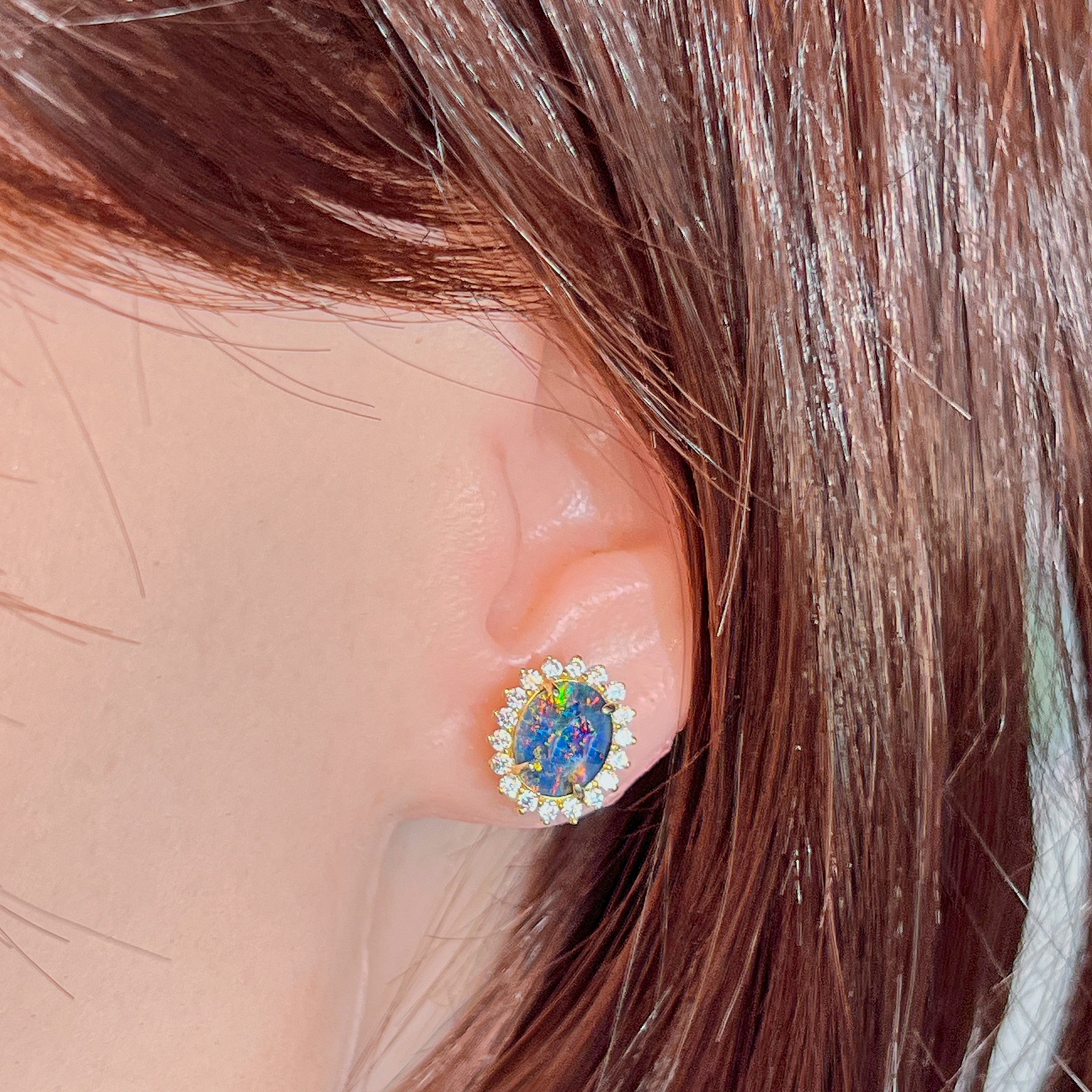 Opal triplet halo cluster earring worn on the ear, showing its scale on the earlobe
