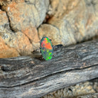 Australian black opal ring in 18kt white gold, green, yellow and red play of colour, shown on driftwood