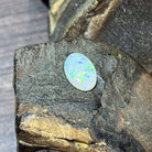 Upright view of the 5.56ct white opal showing green pinfire across its face