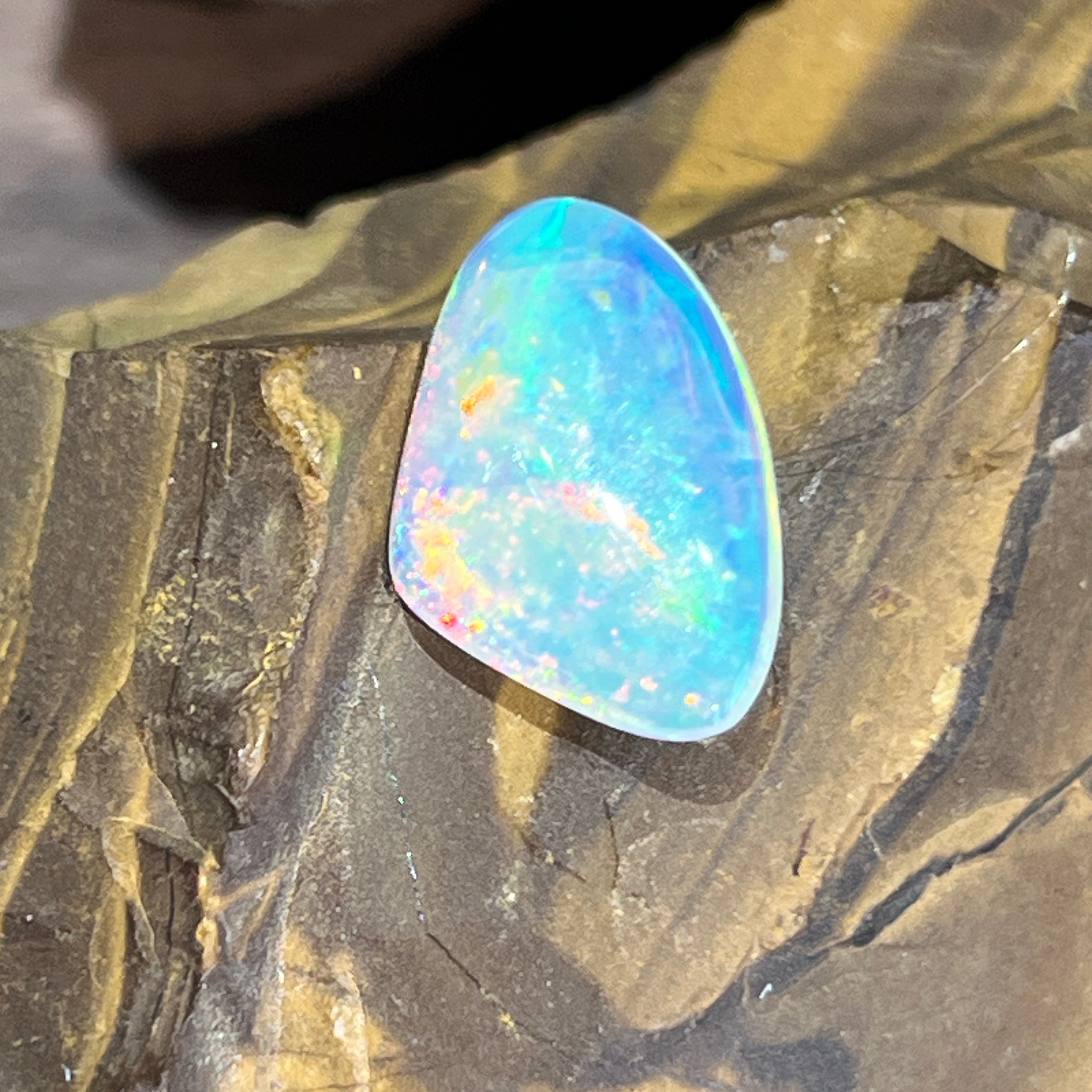 3.1ct Australian crystal opal standing upright on ironstone, showing its domed cabochon profile