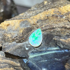1.15ct pear shape crystal opal loose stone, green and yellow flashes, unset, on rock