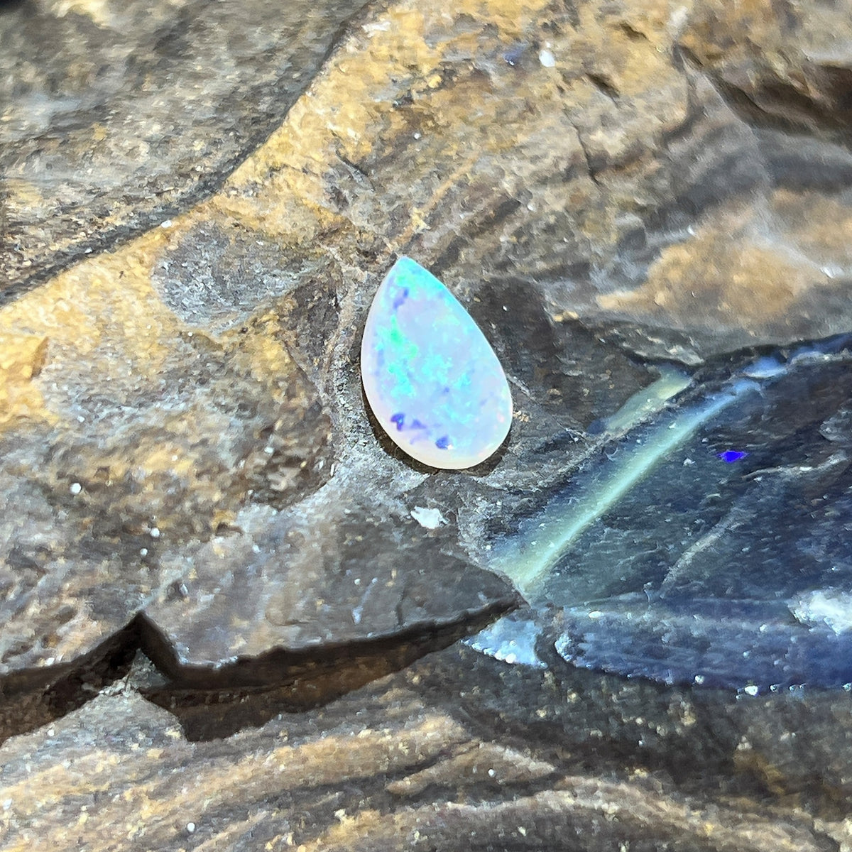 Australian crystal opal 1.15ct pear cabochon, 11.8x7.8mm, green and yellow, loose and unset, on rock