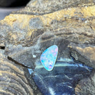 1.36ct triangular crystal opal loose stone, green, red and blue flashes, unset, on rock