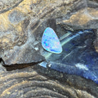 Australian crystal opal 1.36ct triangular cabochon, 13x8mm, green, red and blue, loose and unset, on rock