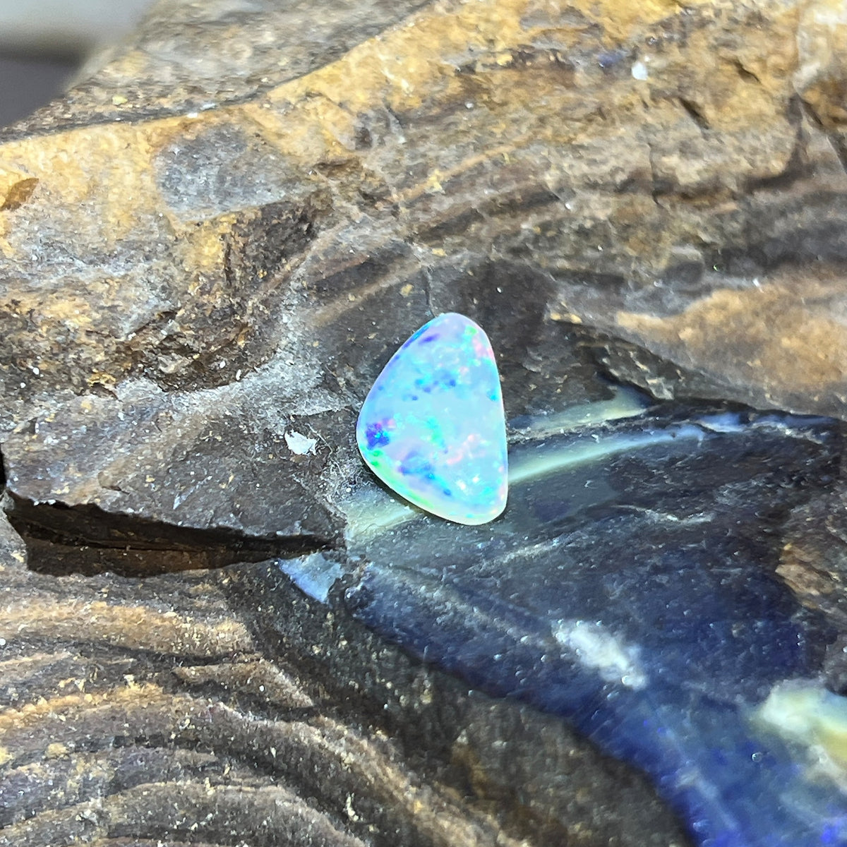 Triangular 13x8mm solid Australian crystal opal, 1.36ct, green, red and blue, unset stone on rock