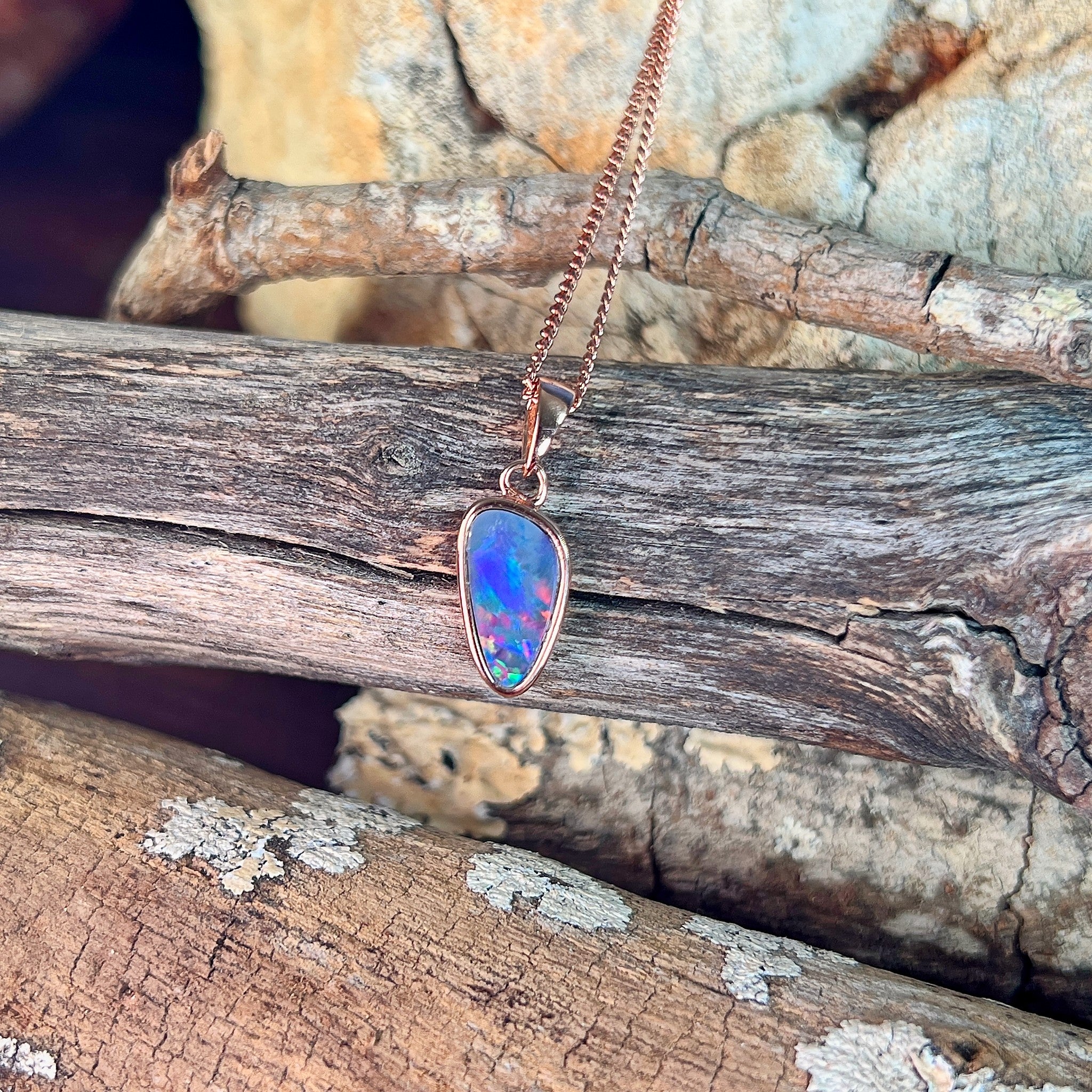 red, green and blue play-of-colour in a 12 x 6.5mm triangular Australian opal doublet pendant