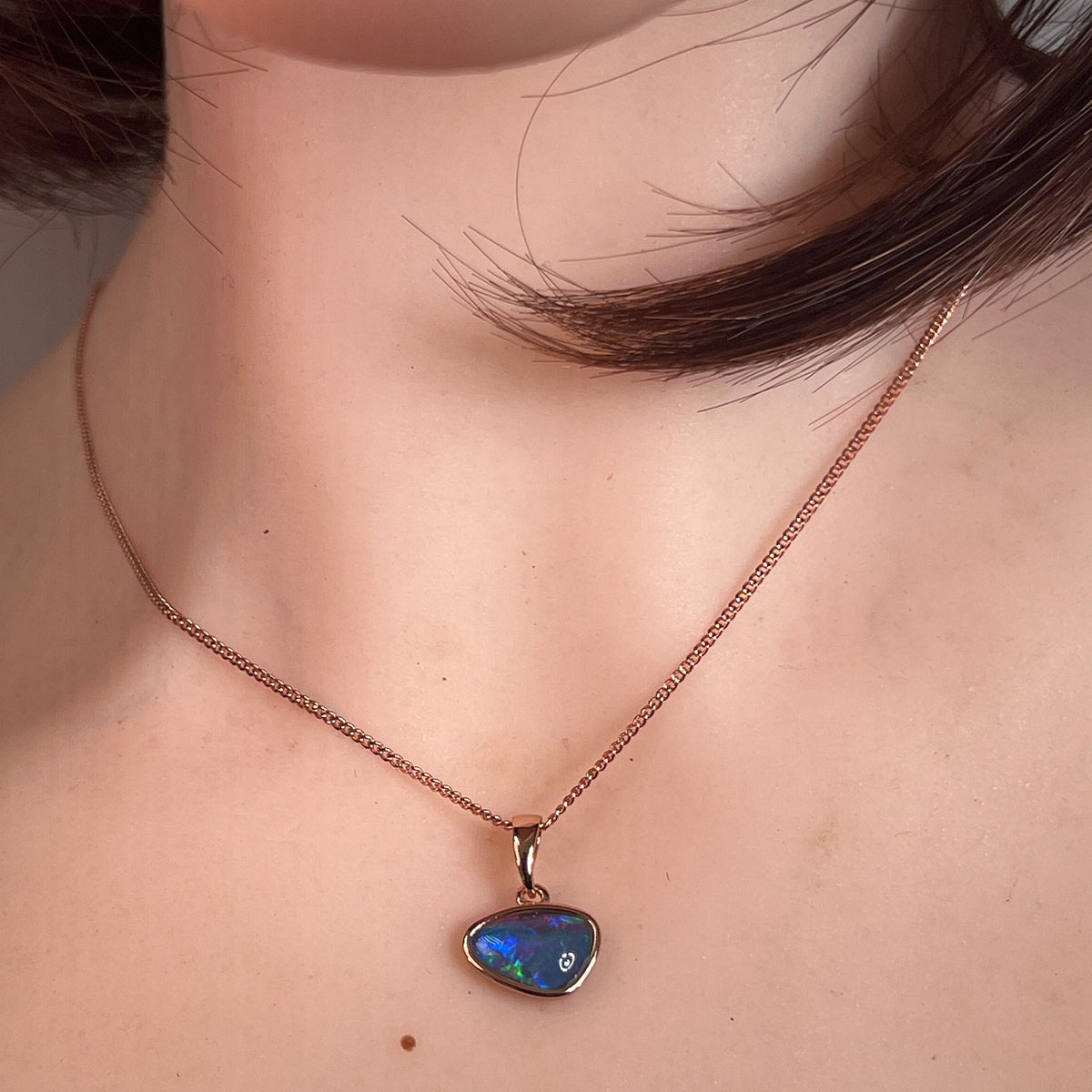 freeform Australian opal triplet pendant in yellow gold-plated silver, worn at the neck
