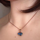 12 x 8mm freeform Australian opal triplet pendant worn at the neck, yellow gold-plated silver