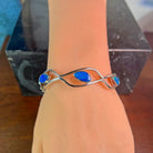 Sterling silver opal doublet wave bangle worn on the wrist