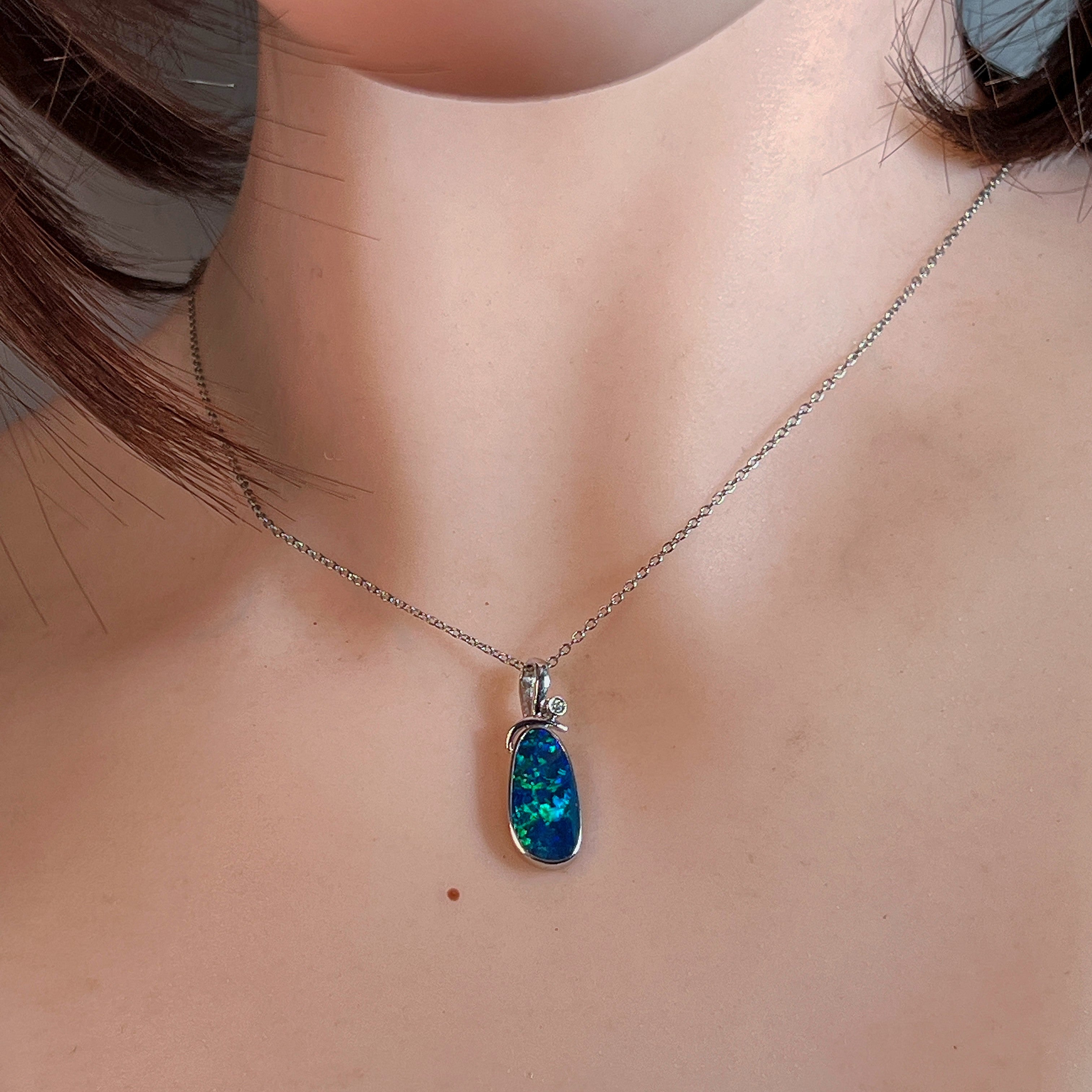Opal doublet pendant necklace worn at the neck, showing its scale on the collarbone