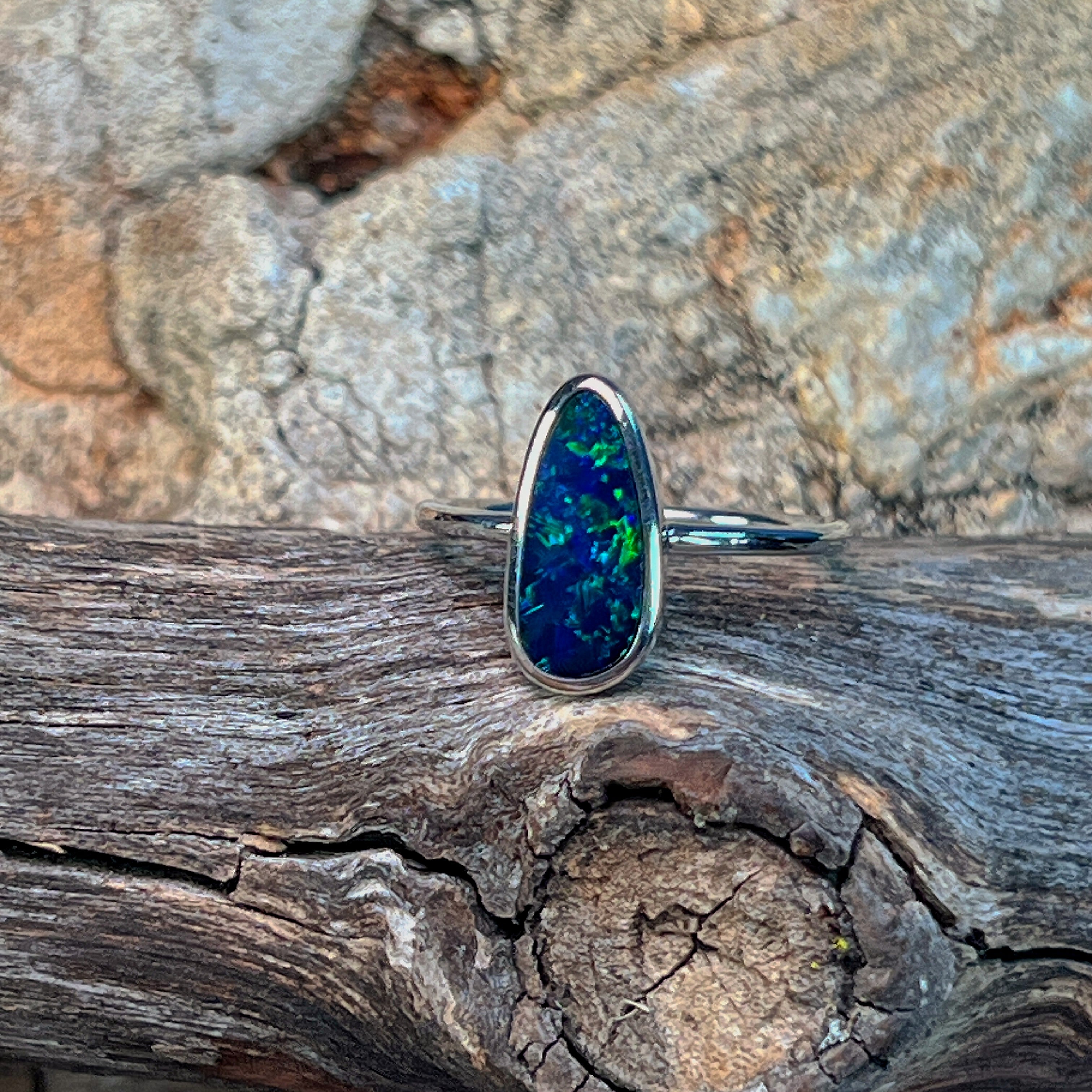 Freeform opal doublet ring in sterling silver showing green flash along the stone