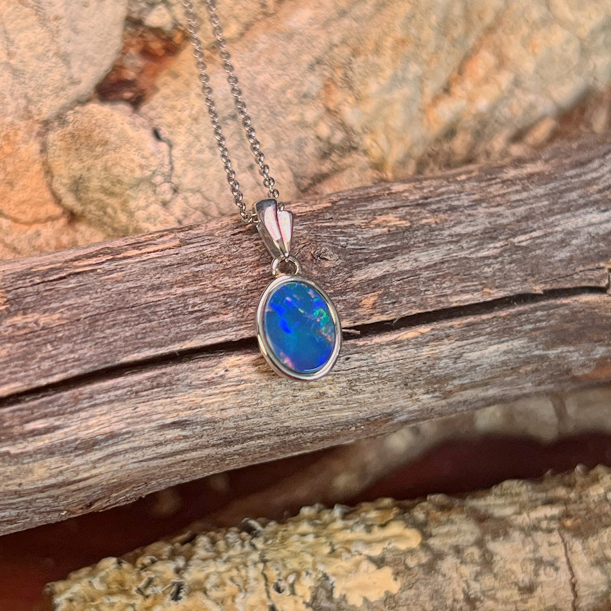 blue, green and red play-of-colour in a 9.5 x 7mm oval Australian opal doublet pendant