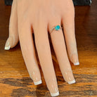 Slanted oval opal doublet ring in silver worn on the hand, full view across the fingers