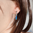 Australian opal doublet earrings worn on the ear, blue and green play-of-colour