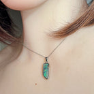 18 x 7mm freeform Australian boulder opal pendant worn at the neck, sterling silver