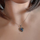 Heart-shaped opal triplet pendant worn at the neck, showing its scale on the collarbone
