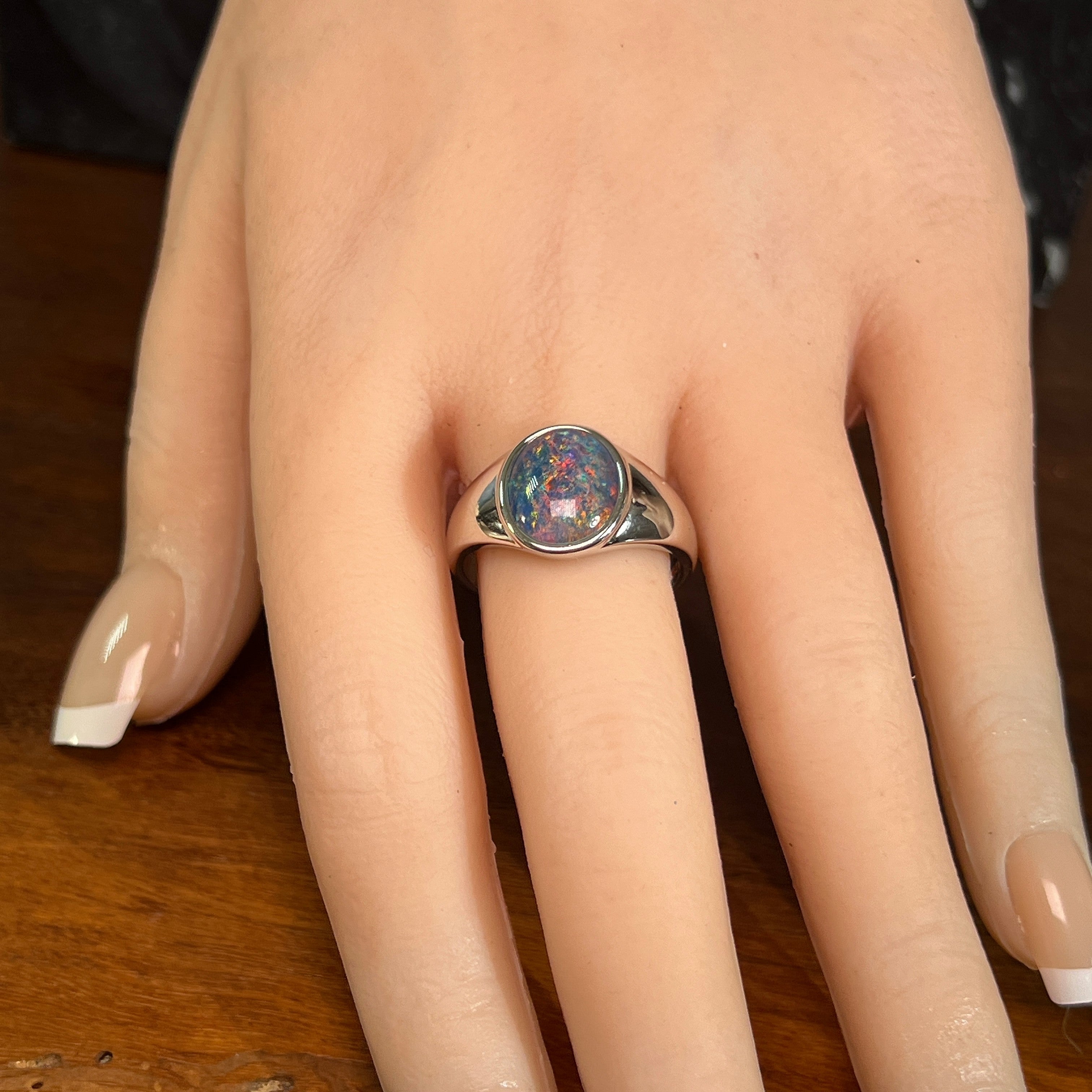 Australian opal triplet ring worn on the hand, red, blue and green play-of-colour