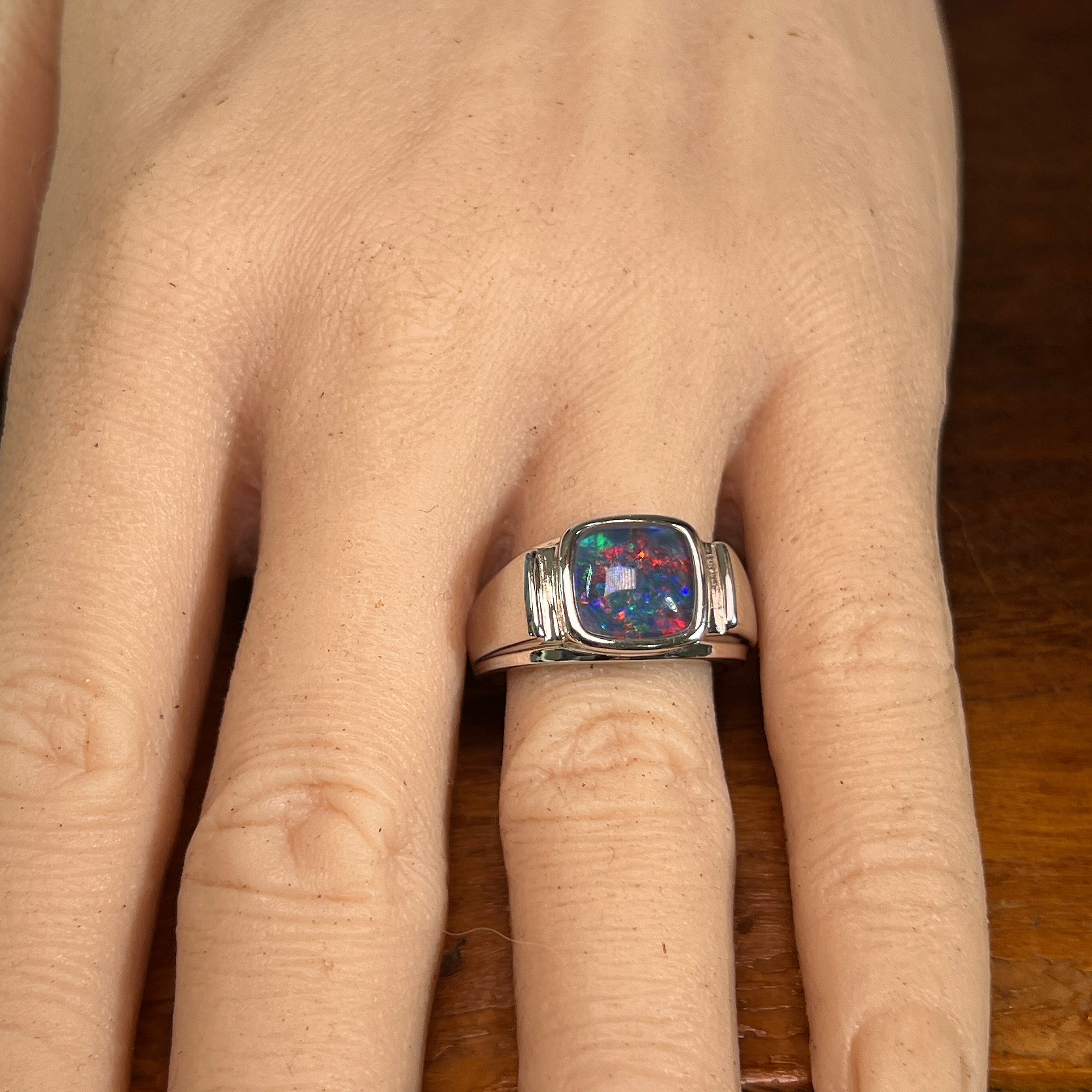 10mm cushion-shaped Australian opal triplet ring on the hand, sterling silver