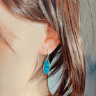 Freeform opal doublet drop earring in white gold worn on the ear, side profile view