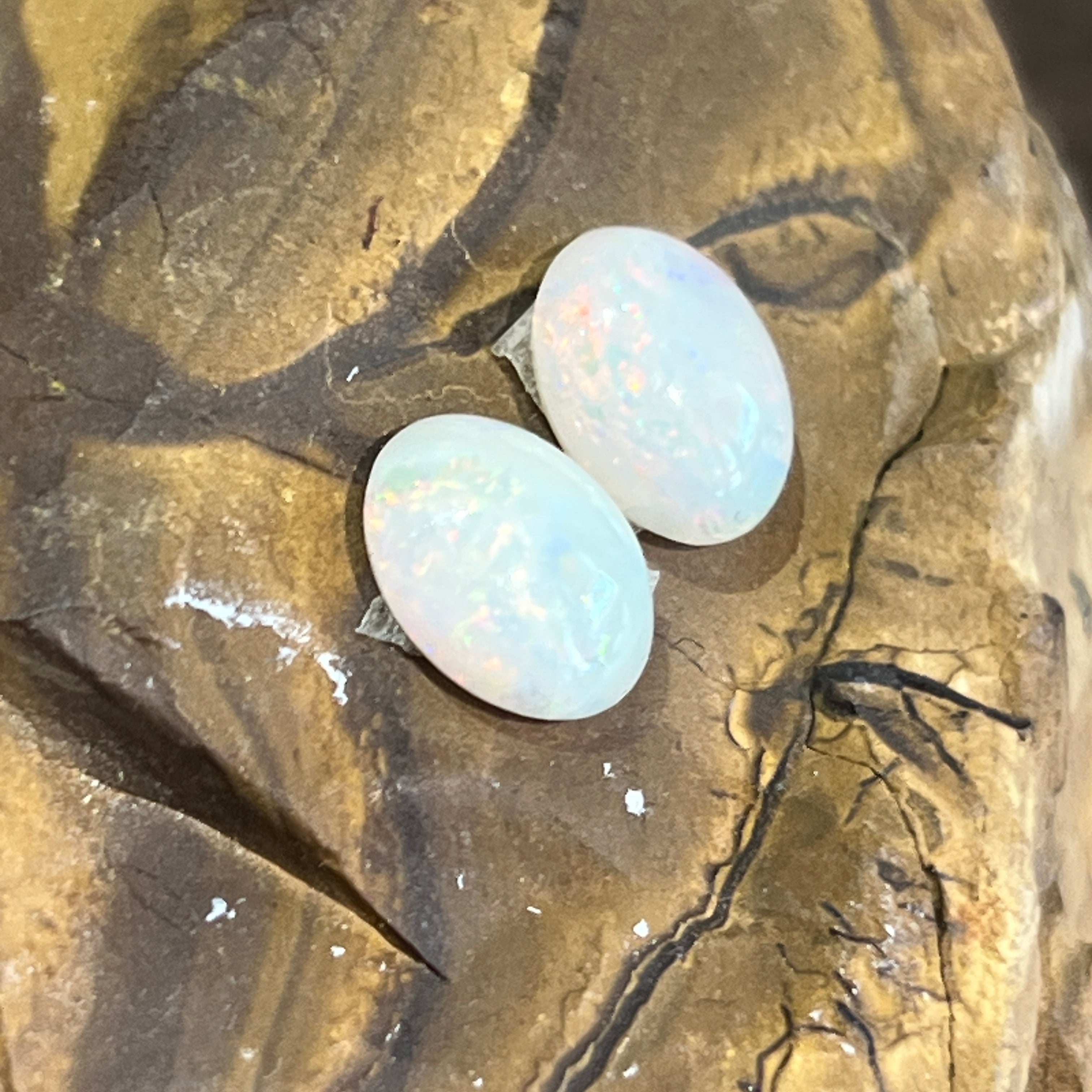 Pair of 9.6x7.9mm Australian white opal ovals on ironstone, green and blue play of colour