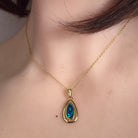 freeform Australian opal doublet pendant in yellow gold-plated silver, worn at the neck