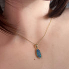 15 x 7mm freeform Australian opal doublet pendant worn at the neck, yellow gold-plated silver