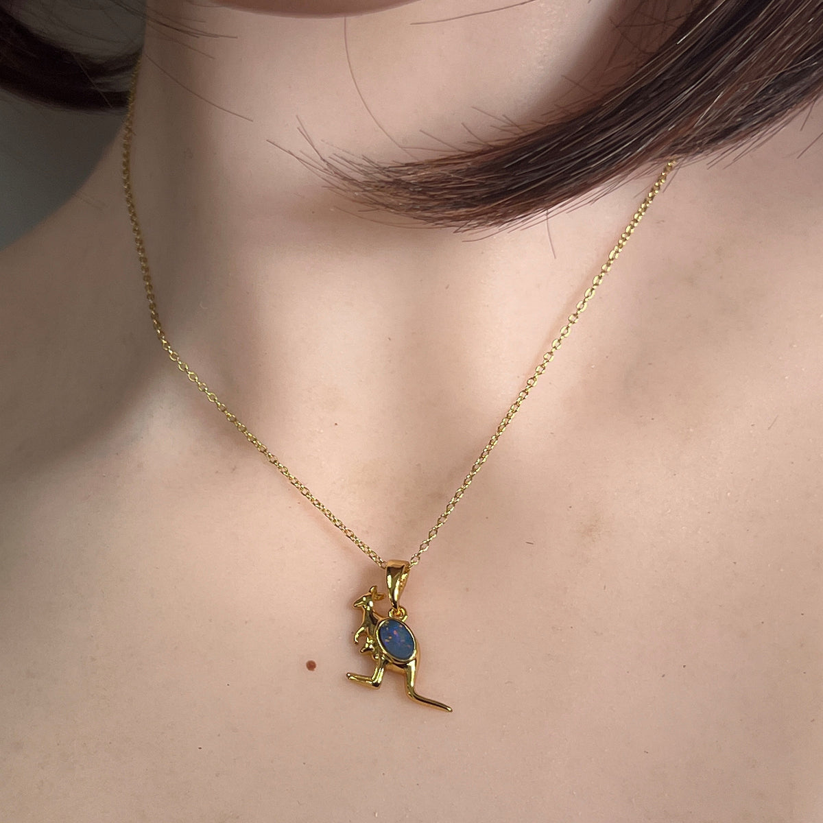 Australian opal doublet pendant worn at the neck, red, blue and yellow play-of-colour