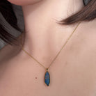 17 x 6mm pear-shaped Australian opal doublet pendant worn at the neck, yellow gold-plated silver