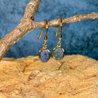 Yellow gold plated sterling silver opal triplet dangling earrings hanging from a driftwood branch