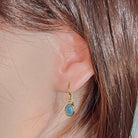 Model wearing the yellow gold plated opal triplet hook earring, showing drop length