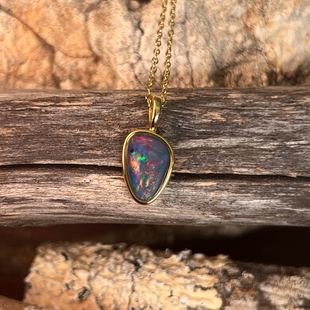 freeform Australian opal triplet pendant in yellow gold-plated silver, blue, red and green play-of-colour