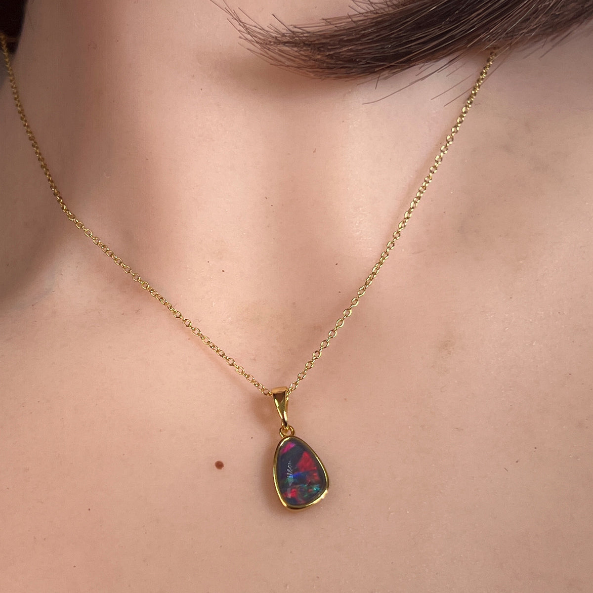Australian opal triplet pendant worn at the neck, yellow gold-plated silver, 11 x 8mm freeform stone